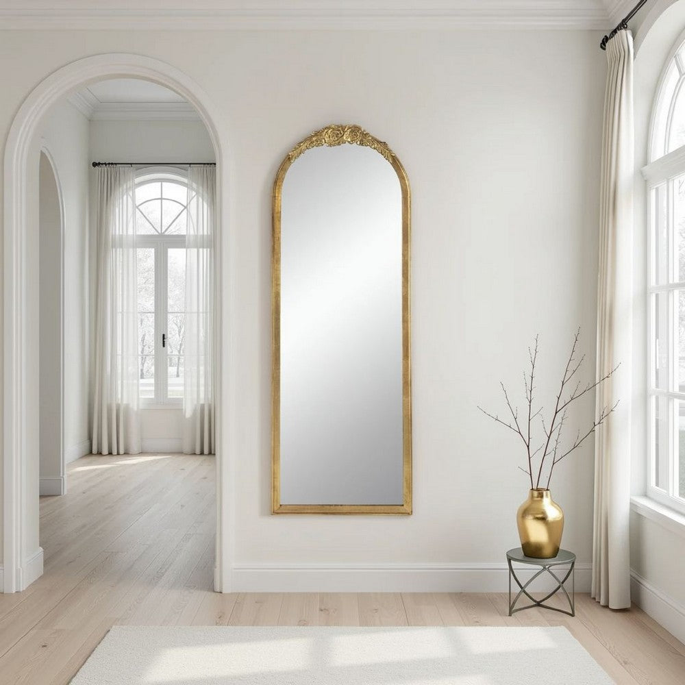 Gold arched floor mirror in a bright room