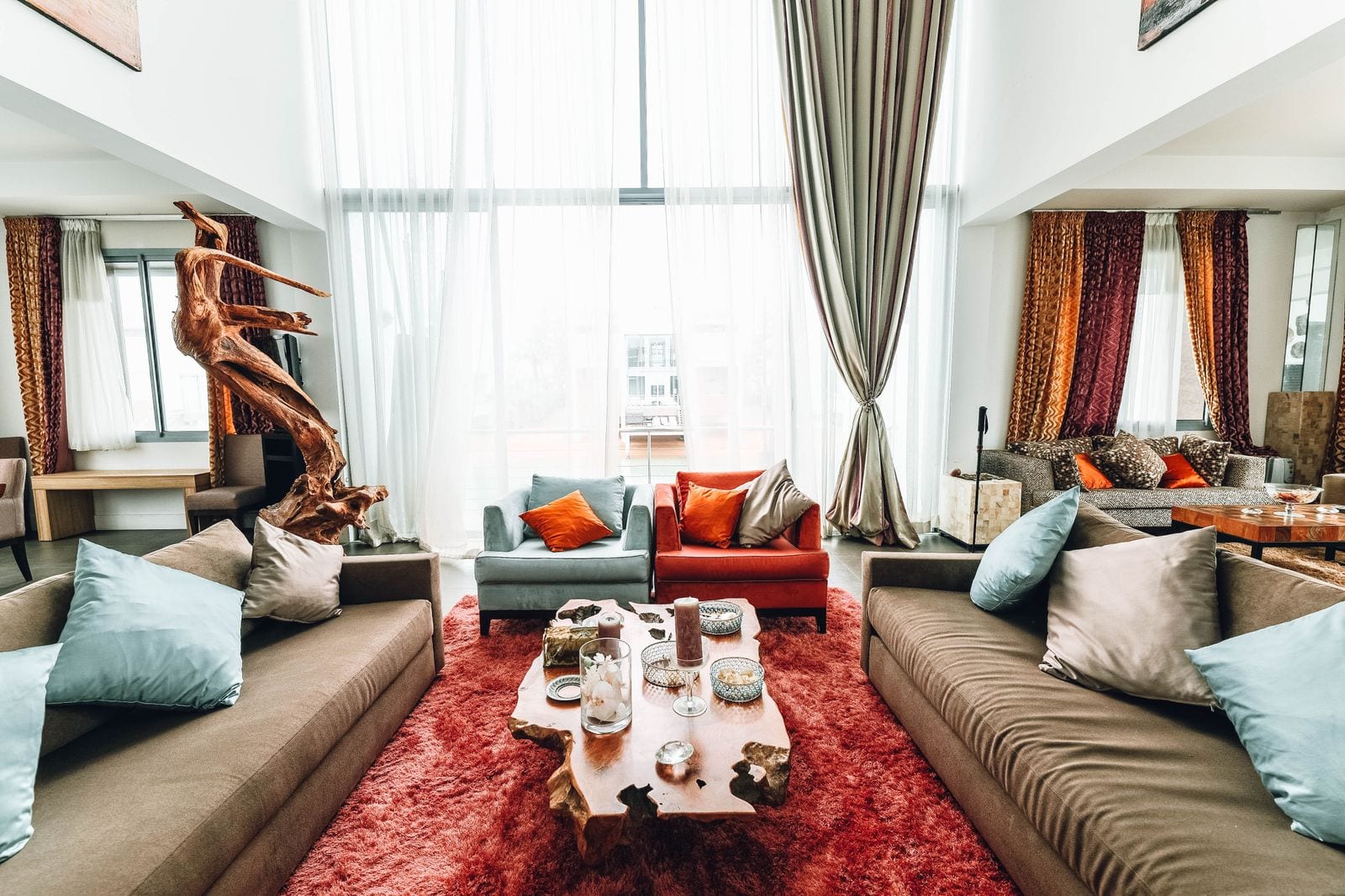 A warmly furnished living room with deep sofas, a live-edge wood coffee table, and layered textiles.
